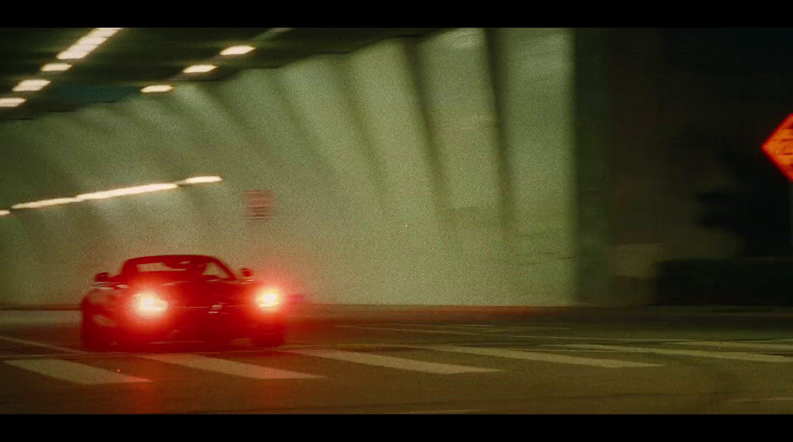 a red sports car driving through a tunnel