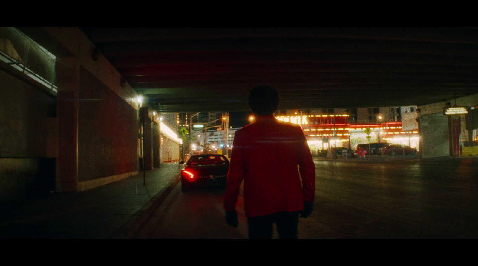 a man walking down a street at night