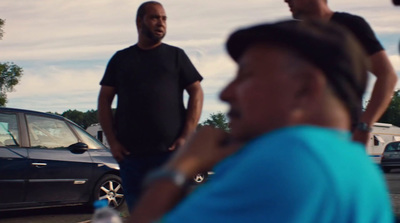 a group of men standing next to each other in a parking lot