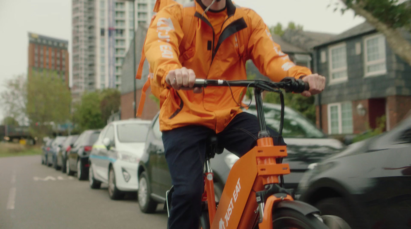 a man riding an orange bike down a street