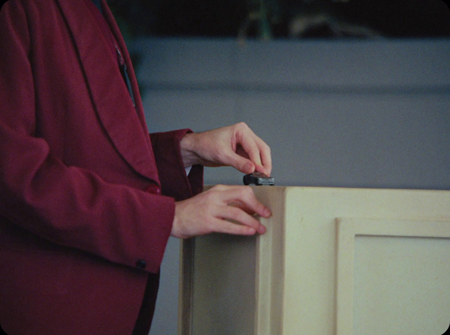 a person in a red jacket is opening a cabinet