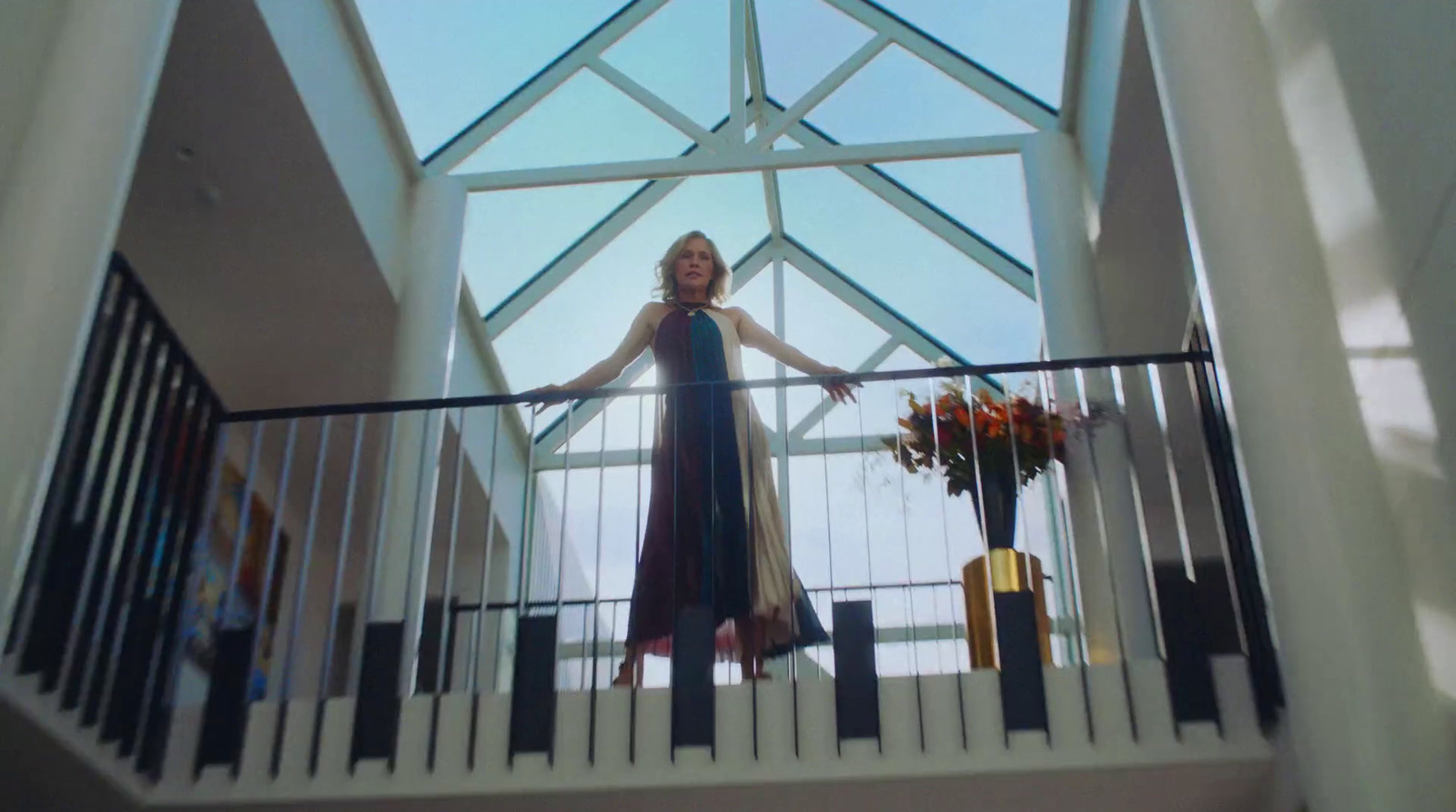 a woman in a blue dress standing on a balcony