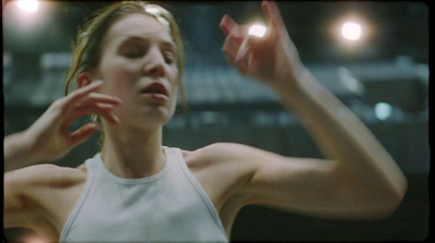 a woman in a white tank top holding her hands up