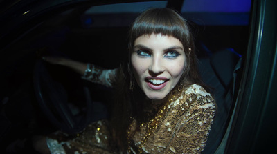 a woman with blue eyes sitting in a car