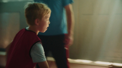 a young boy in a red shirt holding a white frisbee