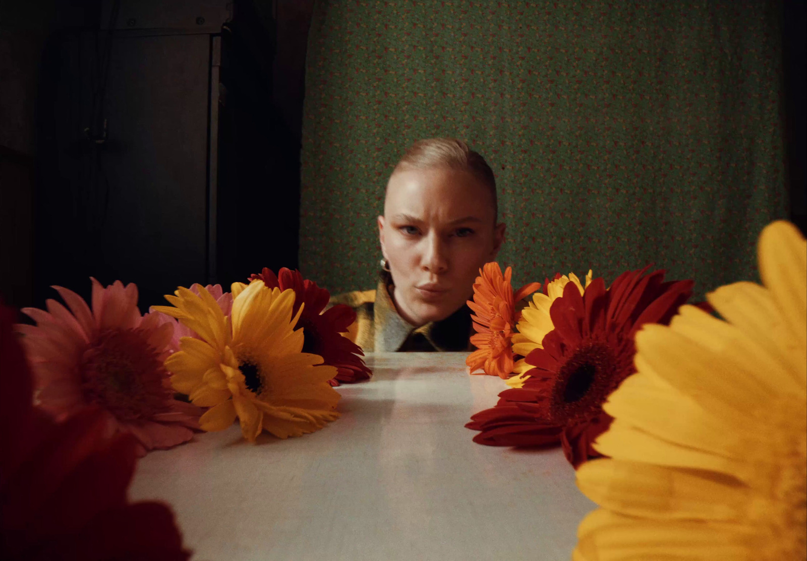 a woman sitting at a table with flowers in front of her