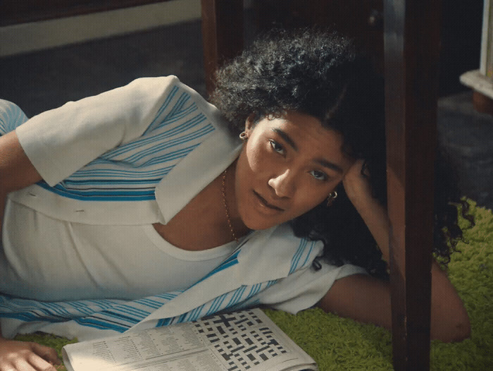 a woman laying on the ground reading a book