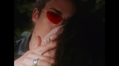 a man with red sunglasses blowing his nose