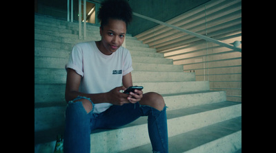 a person sitting on some stairs looking at a cell phone