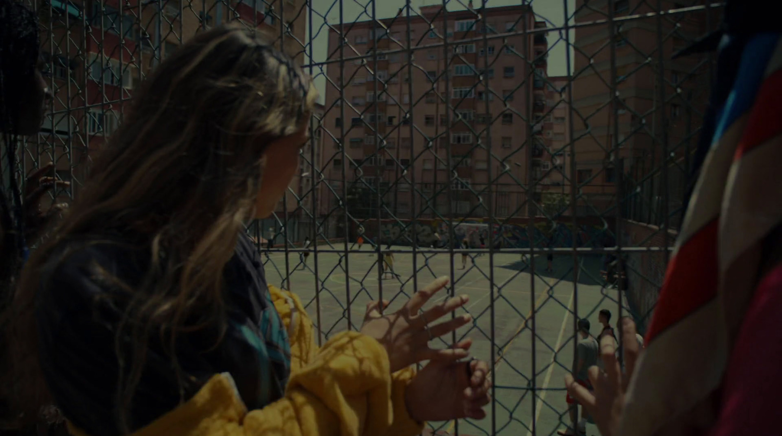 a woman standing in front of a fence with her hands out