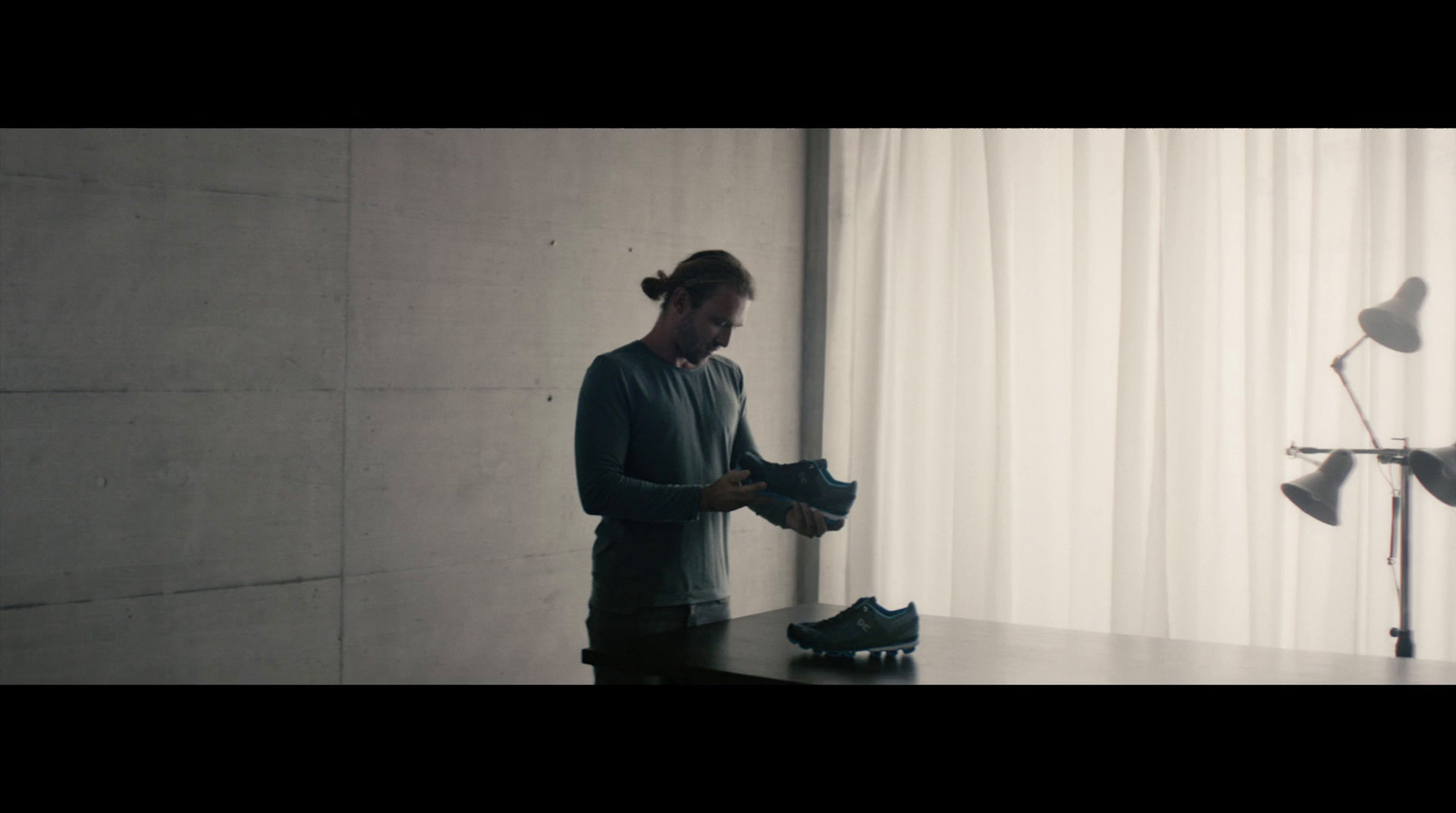 a man standing next to a table with a pair of shoes on it