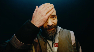 a man with a beard holding his hands to his face