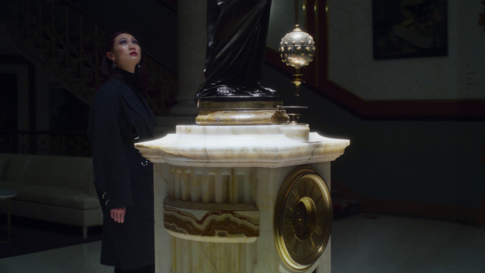 a woman standing next to a clock in a room