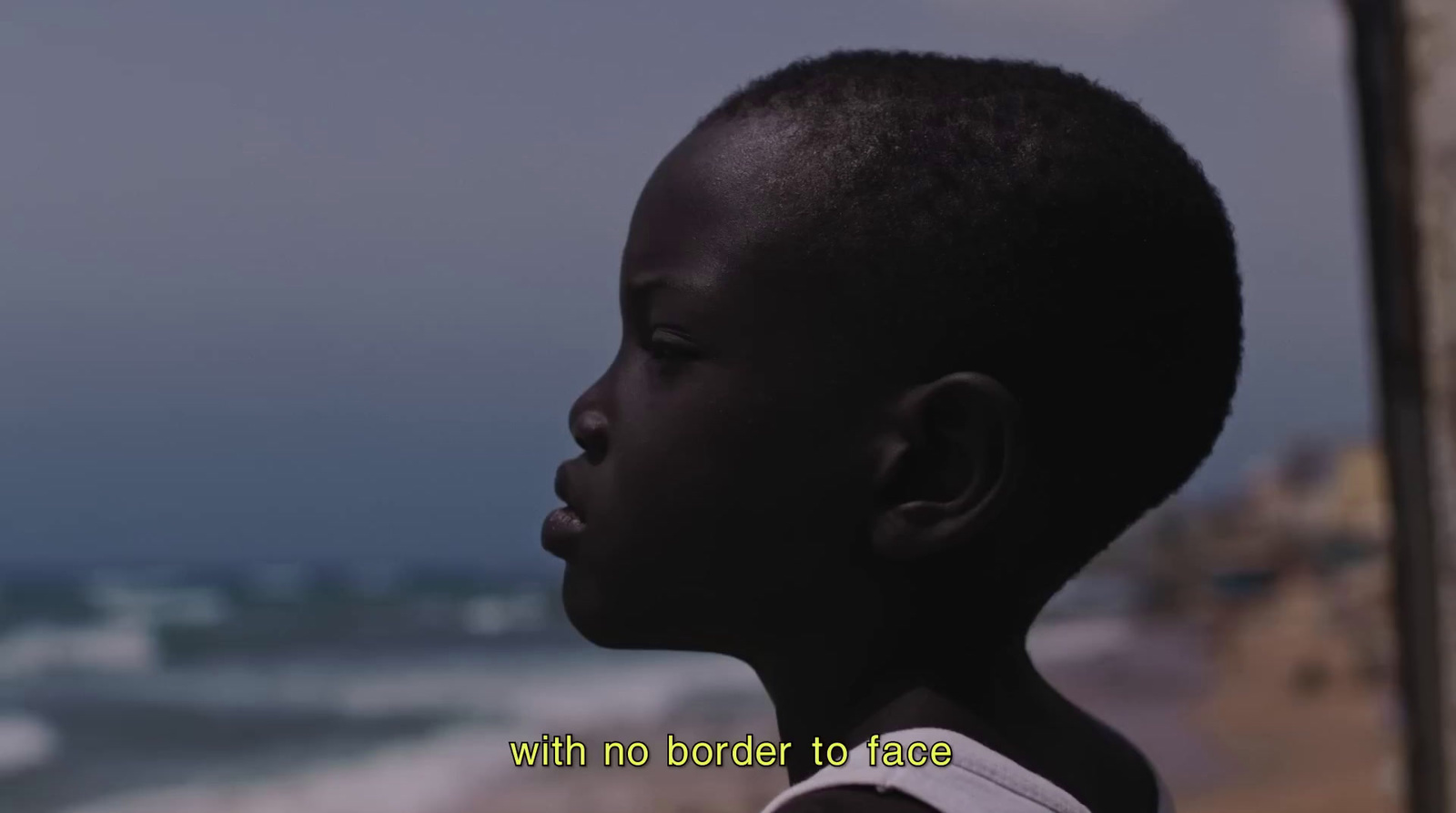 a young boy looking out at the ocean