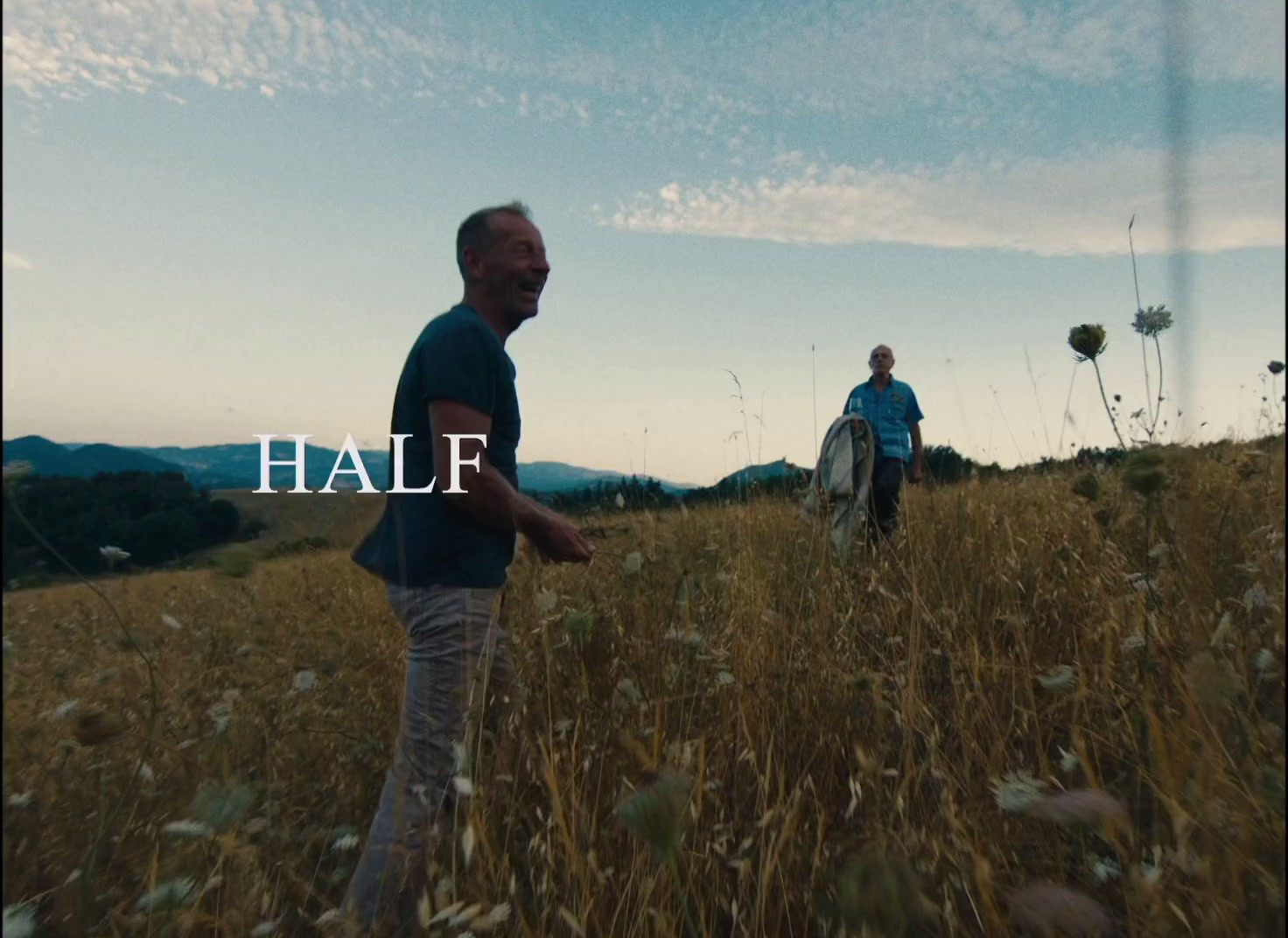 a couple of men standing on top of a grass covered field