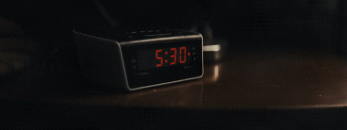 an alarm clock sitting on top of a wooden table