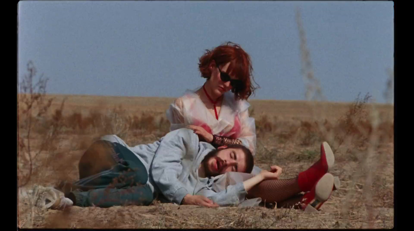 a man laying on the ground next to a woman