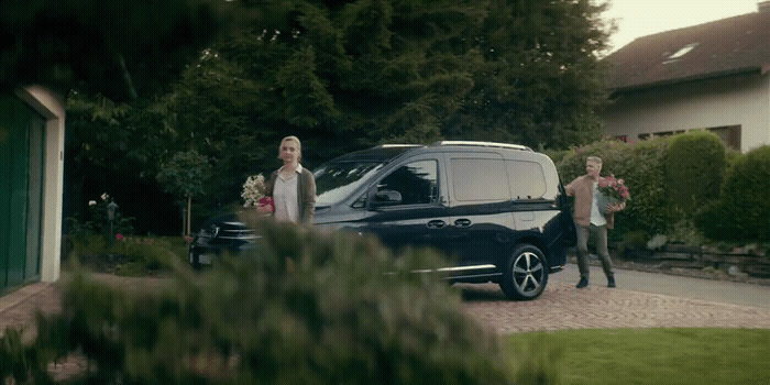 a man and a woman standing in front of a van