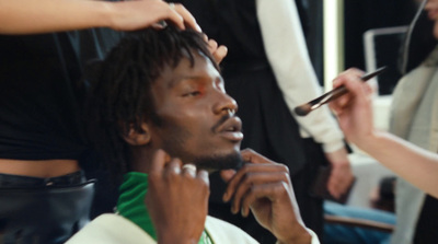 a man getting his hair cut by a woman