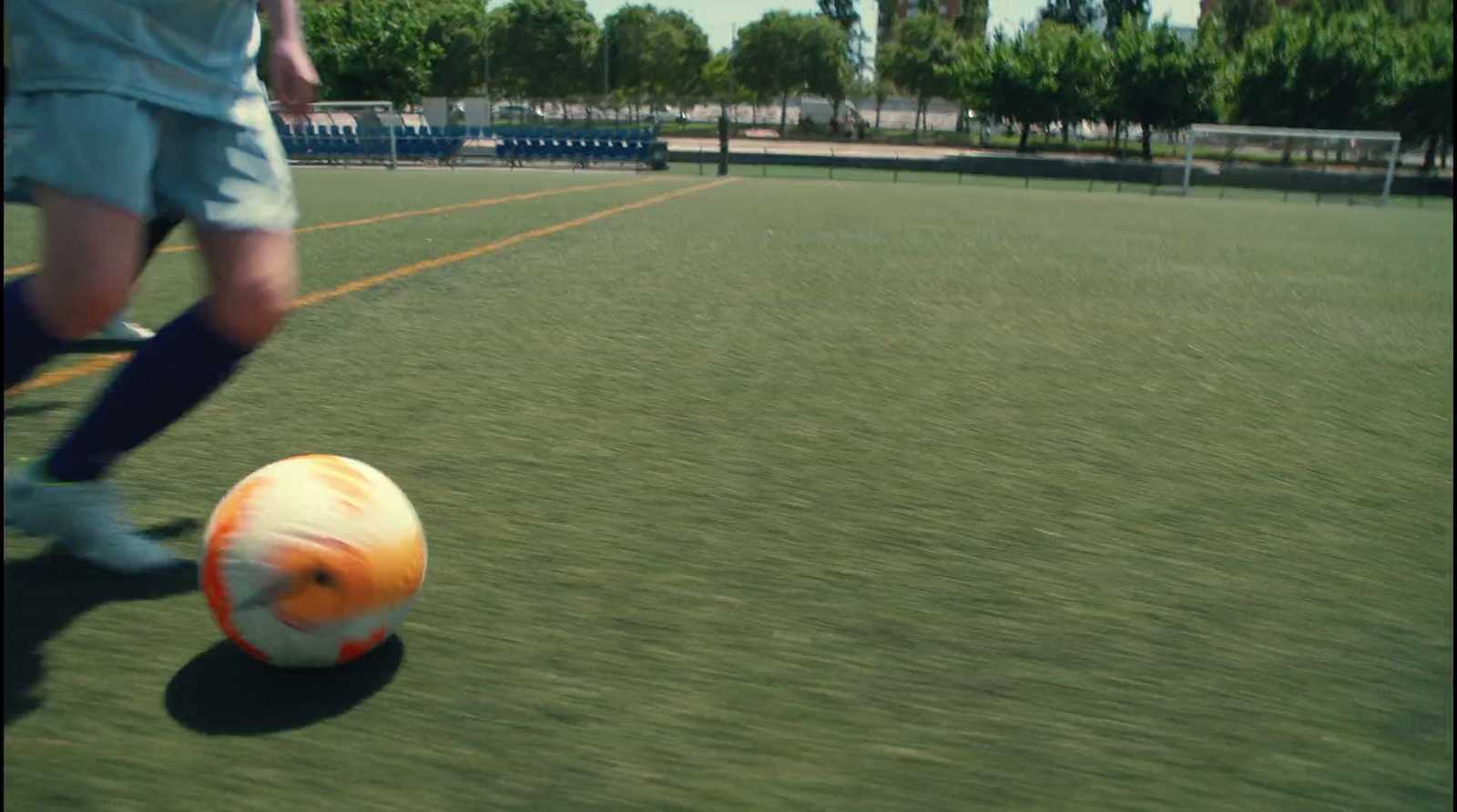 a person kicking a soccer ball on a field