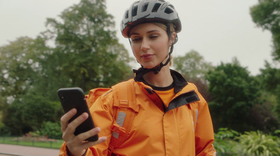 a woman wearing a helmet looking at her cell phone