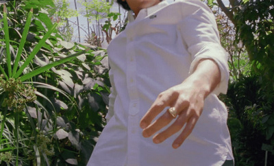 a man in a white shirt is holding out his hand