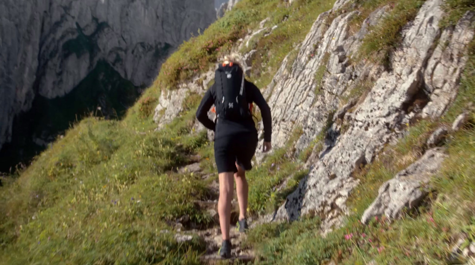 a woman hiking up a steep mountain trail