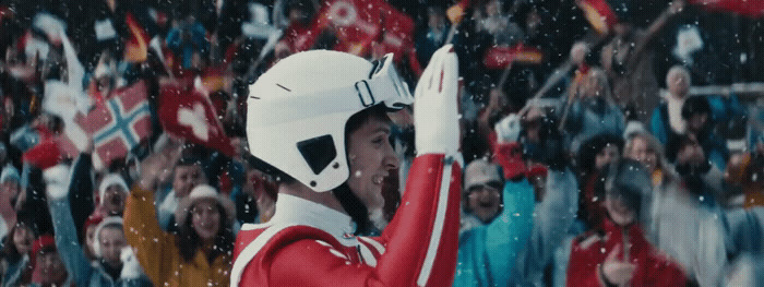 a man in a red and white uniform waves to a crowd