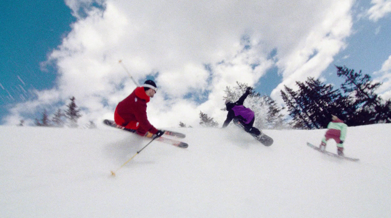 a couple of people riding skis down a snow covered slope