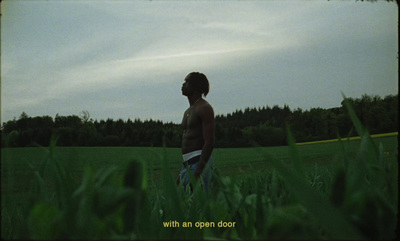 a man standing in the middle of a lush green field