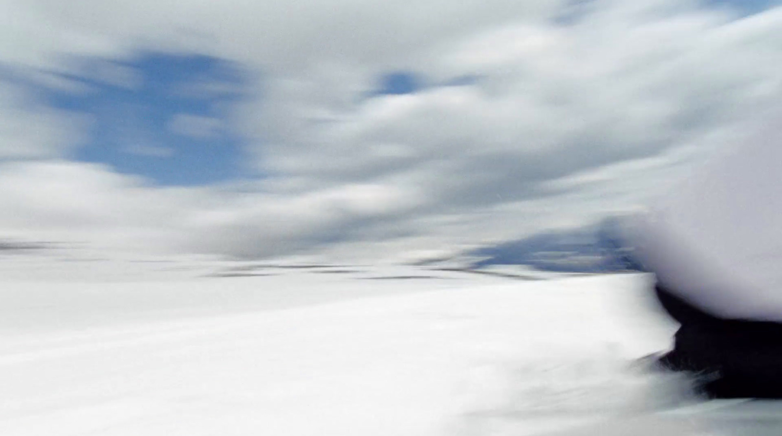 a man riding a snowboard down a snow covered slope