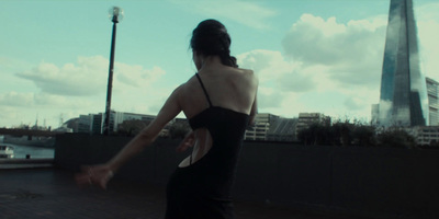 a woman in a black dress holding a frisbee