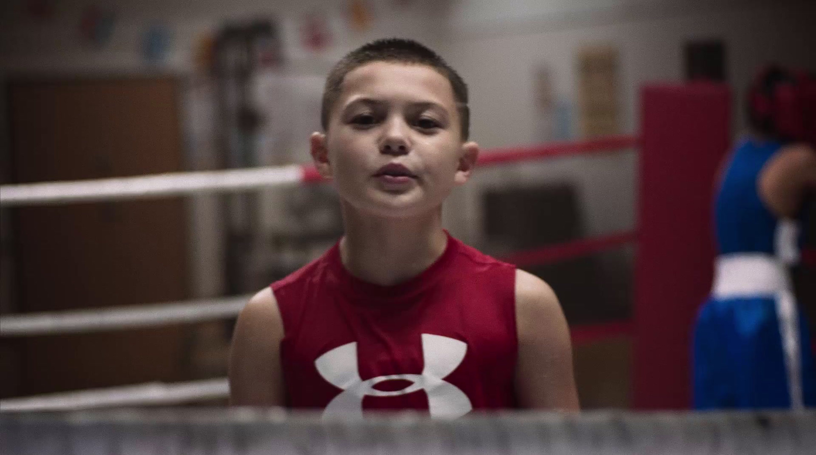 a young boy standing in a boxing ring