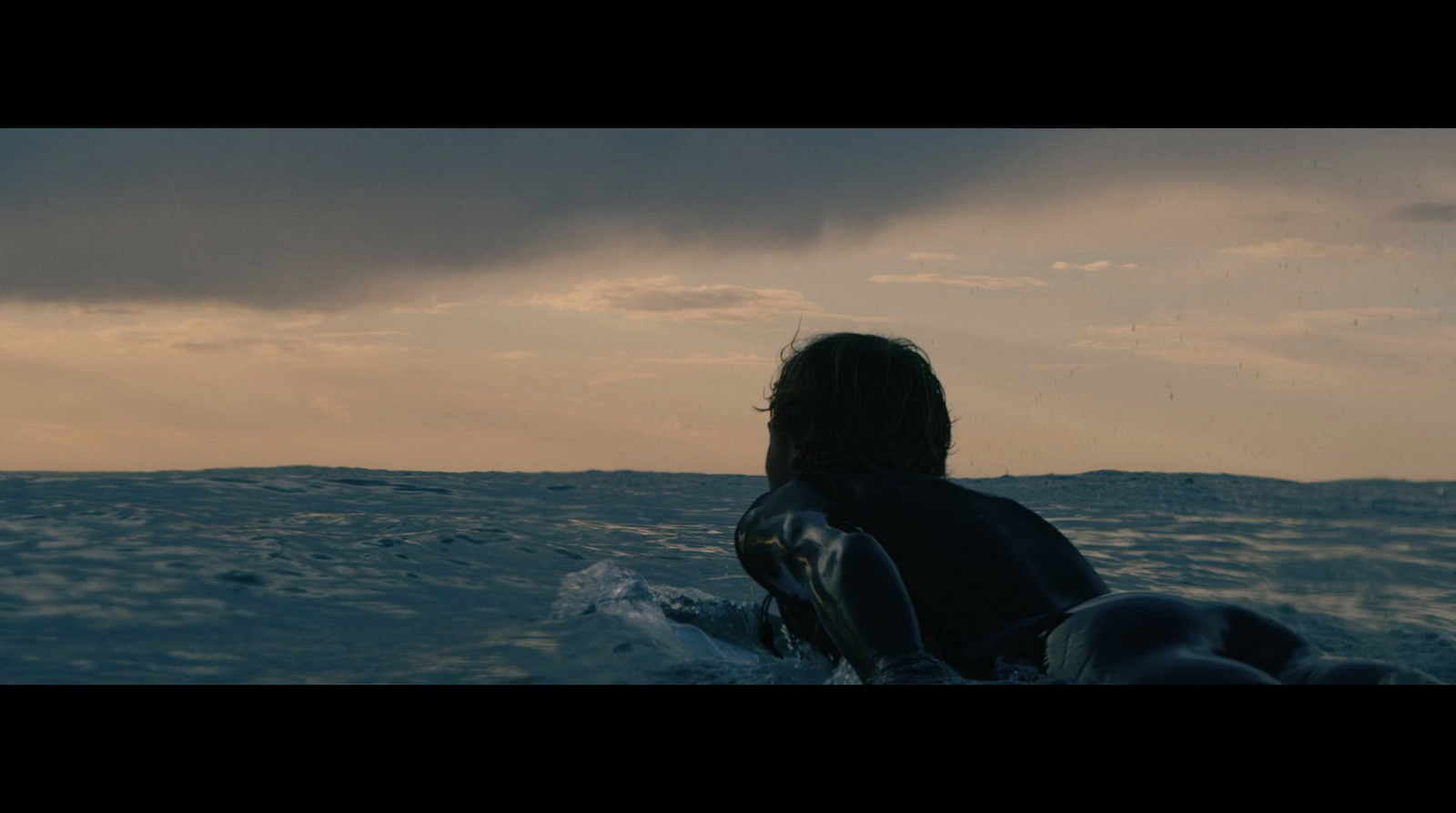 a person sitting on a surfboard in the ocean