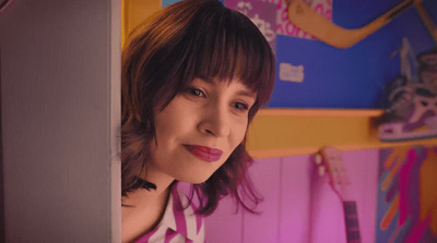 a woman standing in front of a pink wall