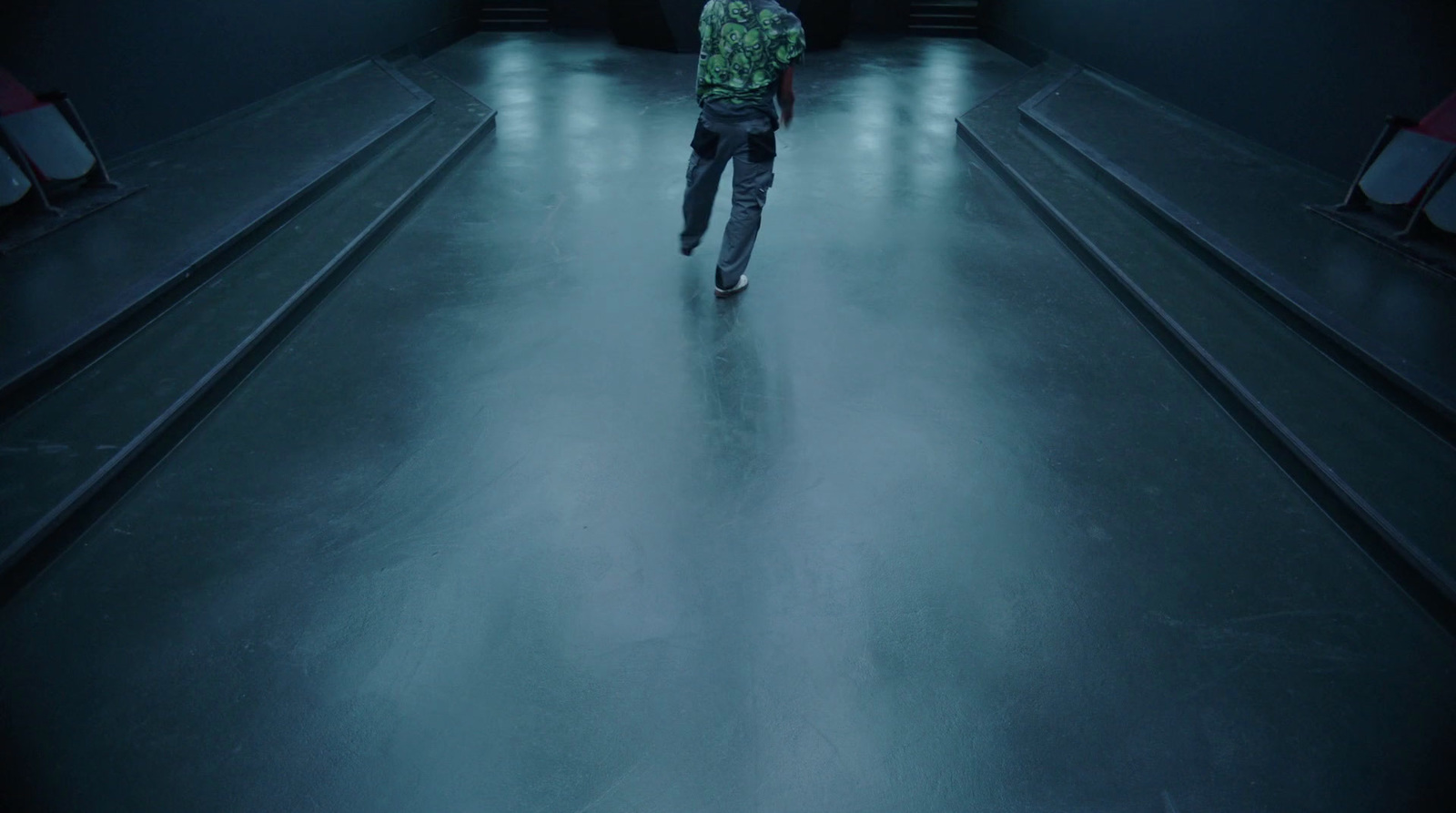 a man is walking down a dark hallway