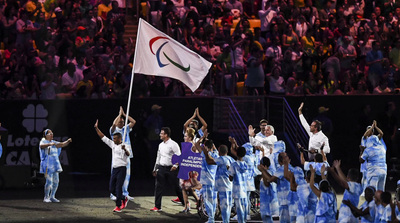 a group of people standing on top of a field holding a flag