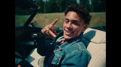 a man sitting in a car making a peace sign