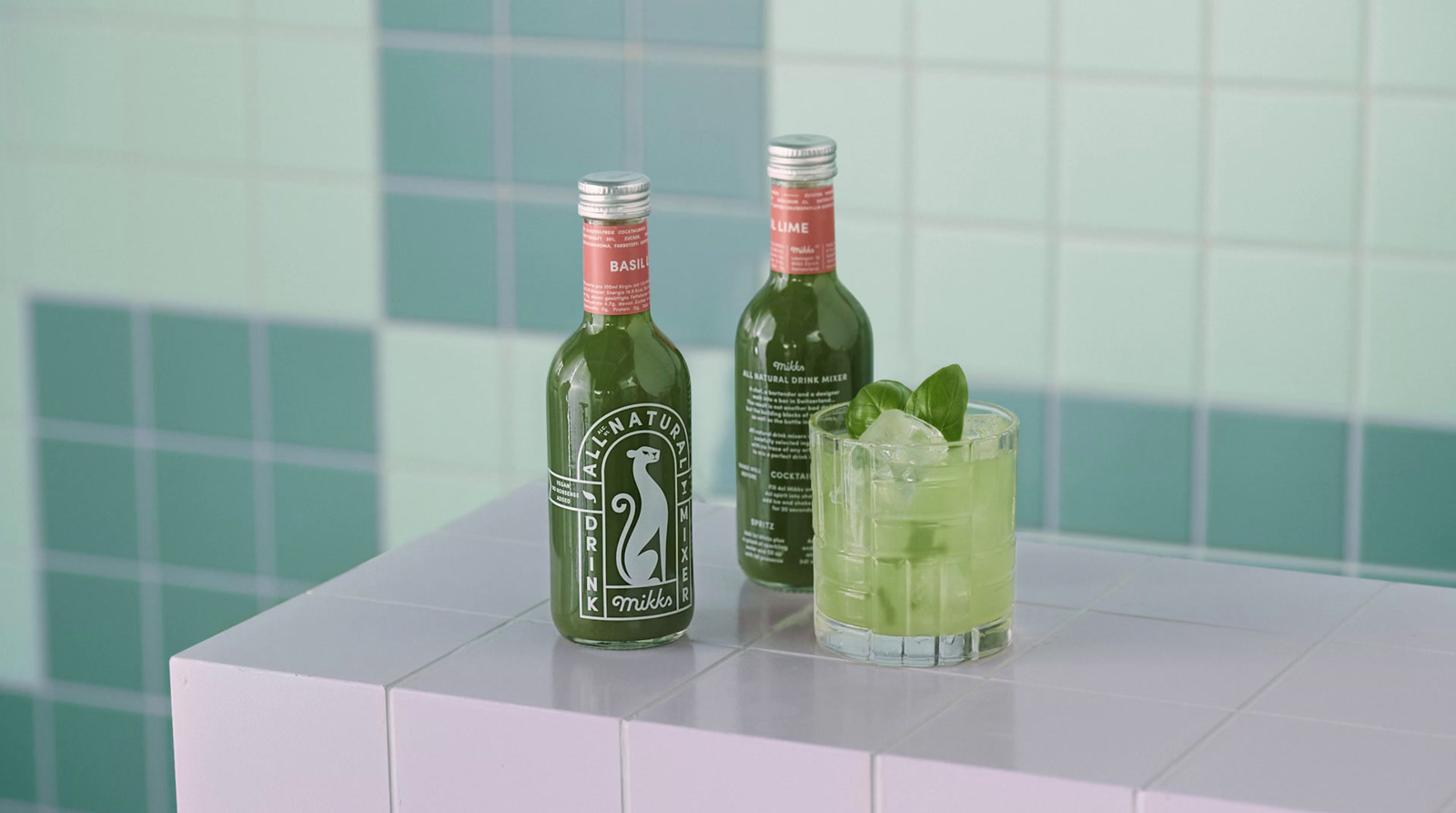 two bottles of alcohol sitting on a counter next to a glass