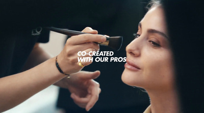 a woman getting her make - up done by a professional makeup artist