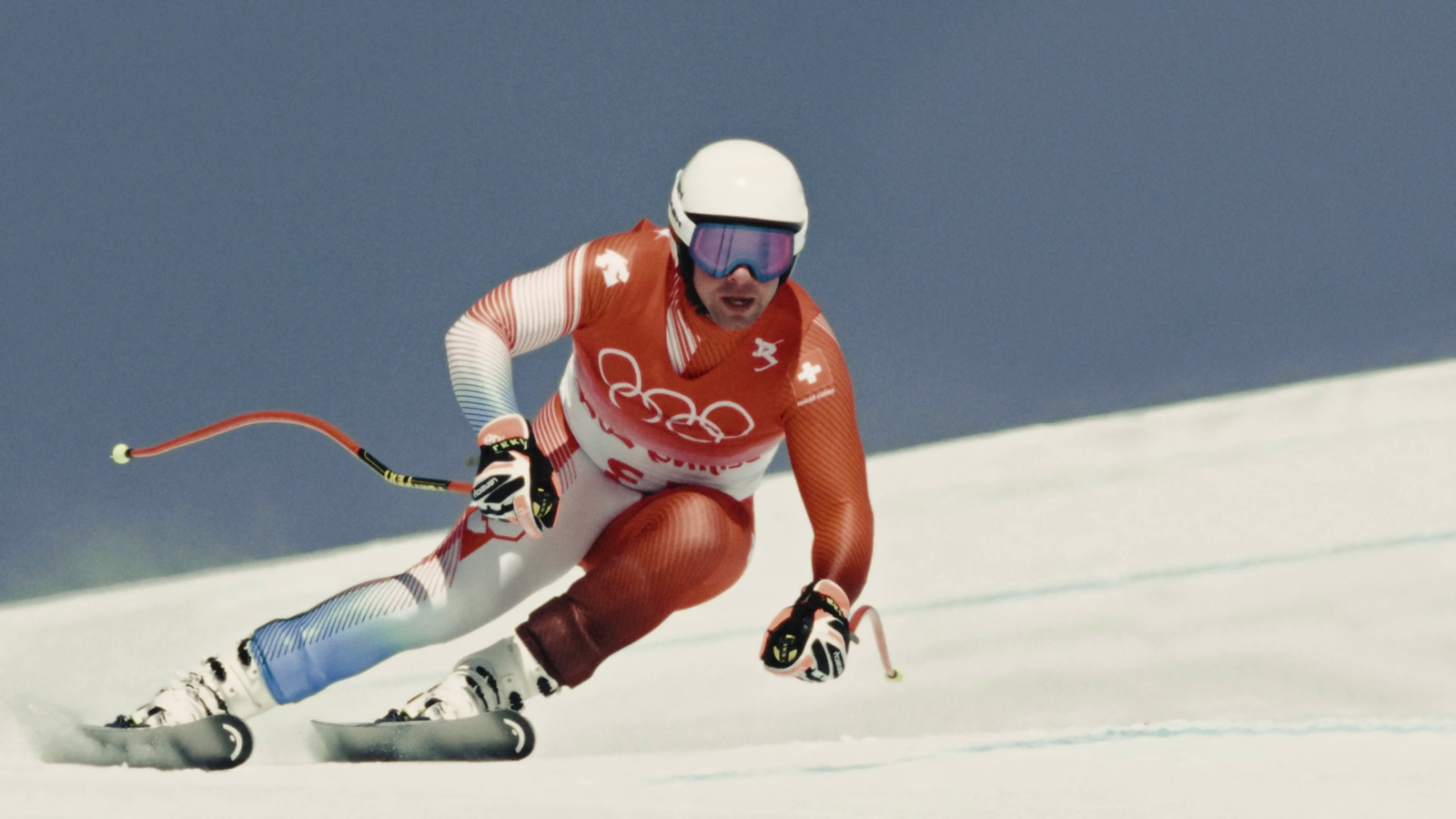 a man riding skis down a snow covered slope