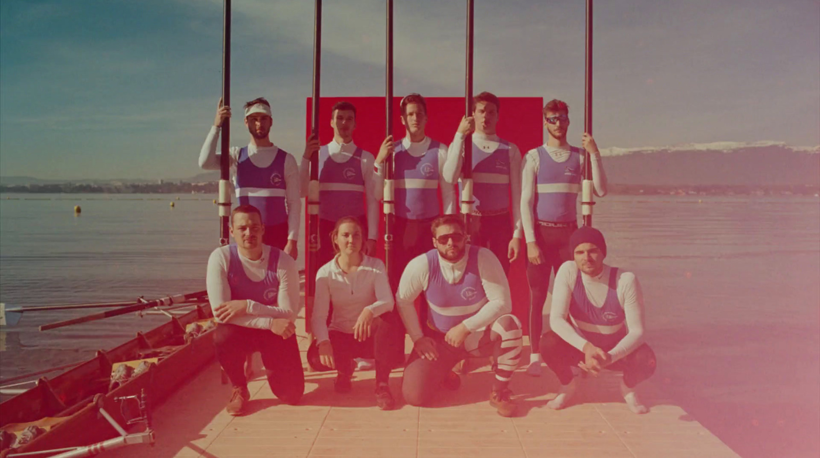 a group of people standing next to each other near a body of water