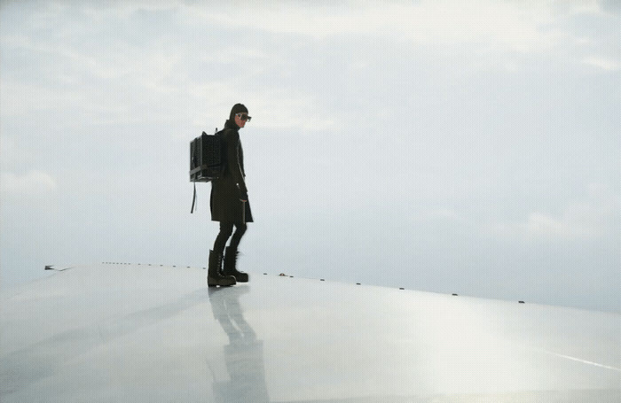 a man standing on top of a roof with a backpack