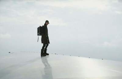 a man standing on top of a roof with a backpack