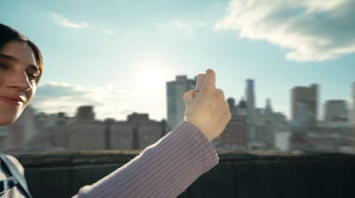 a woman holding a cell phone up to the sky