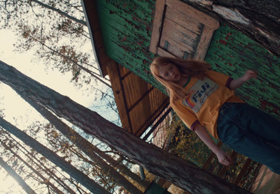 a young girl standing on top of a wooden structure