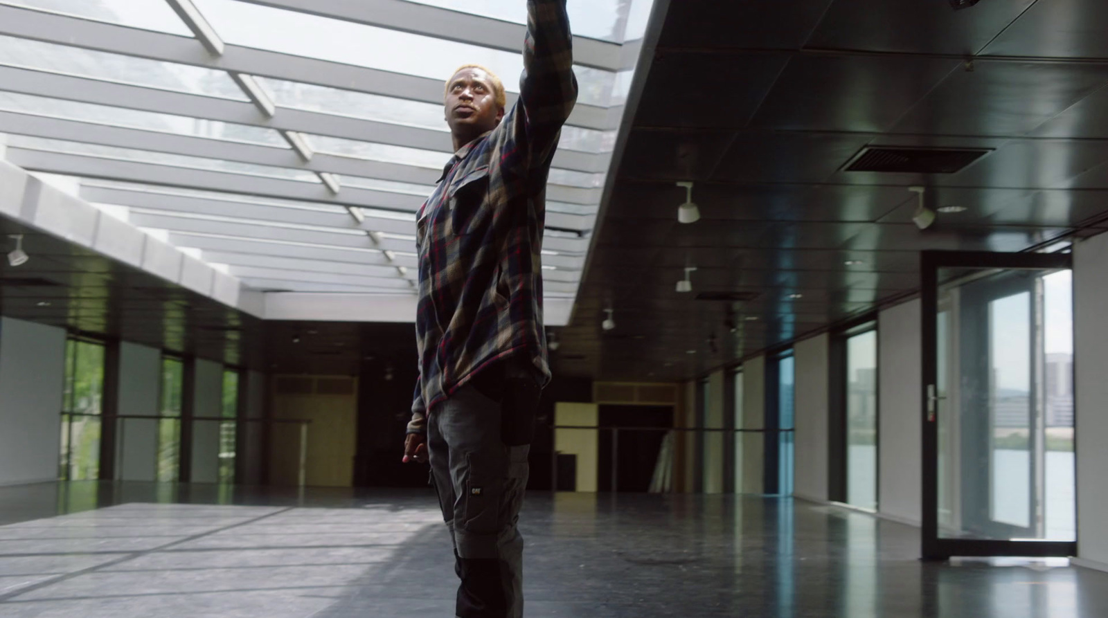 a man standing in a hallway holding a skateboard