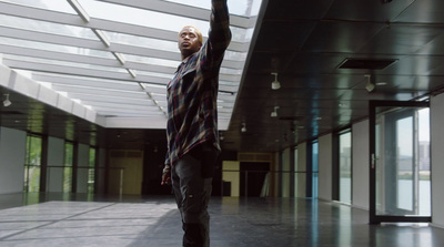 a man standing in a hallway holding a skateboard