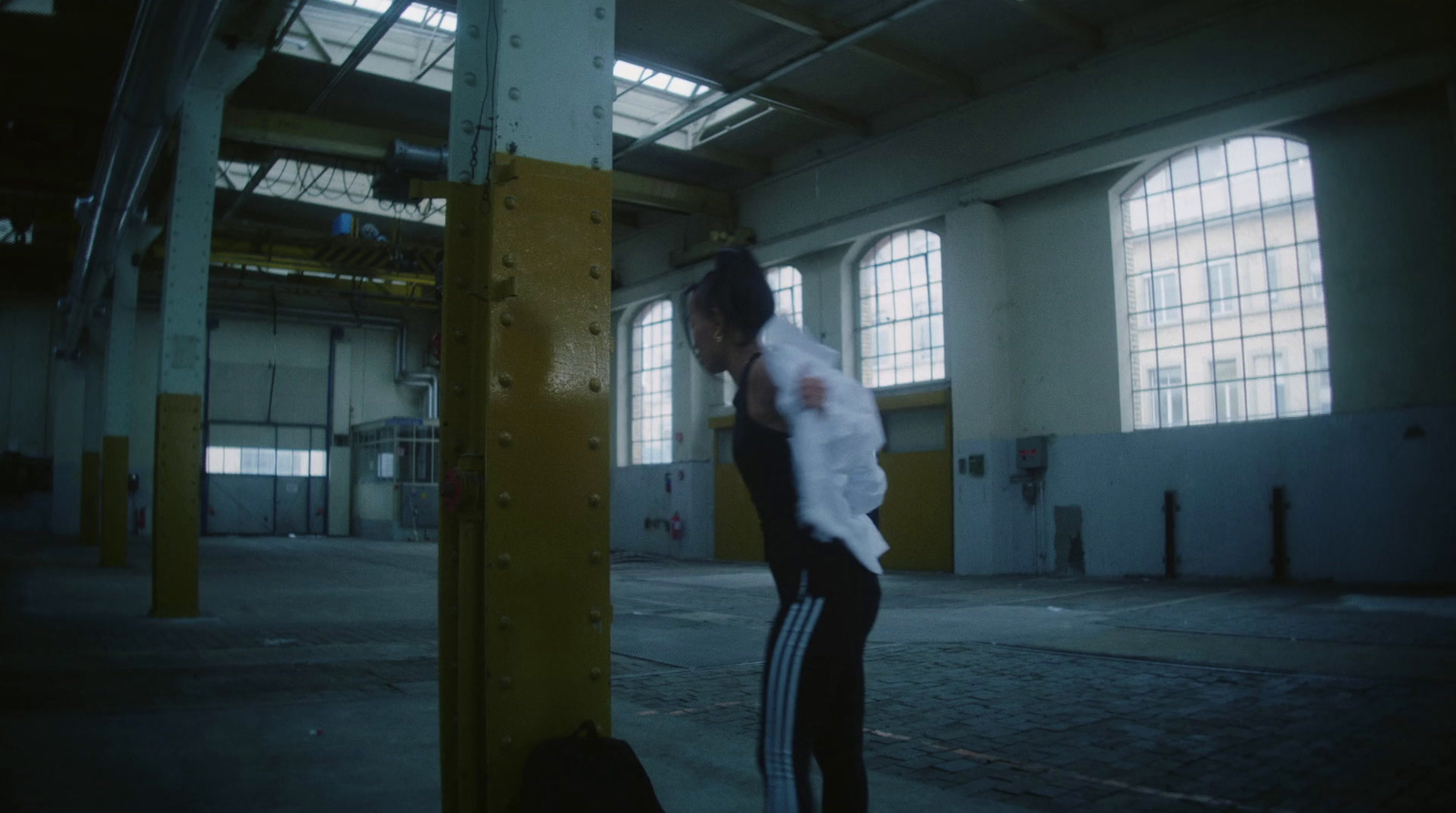 a man standing on a pole in a warehouse