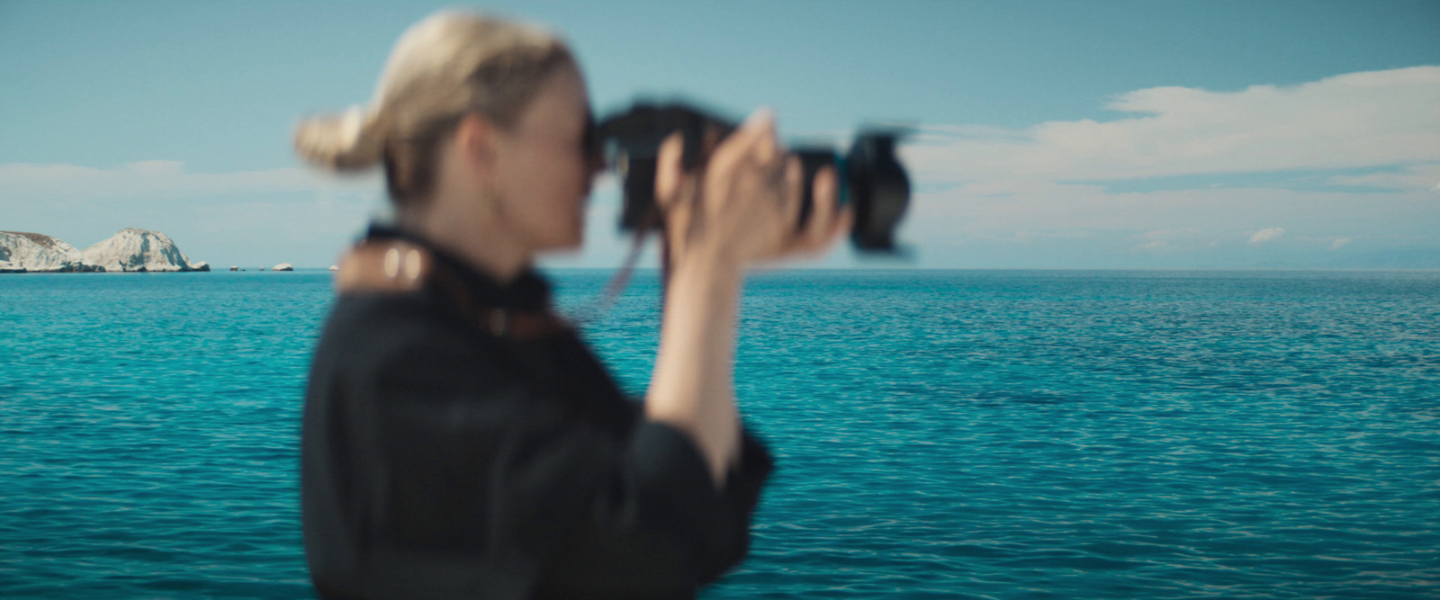 a woman standing on a boat looking through binoculars